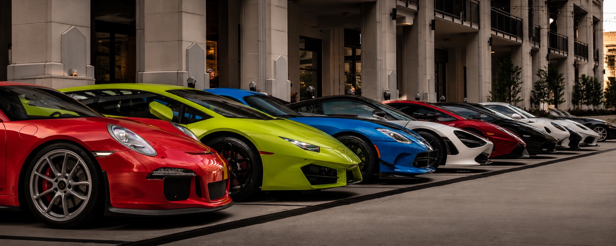 A curated lineup of exotic cars presented outside a luxury property